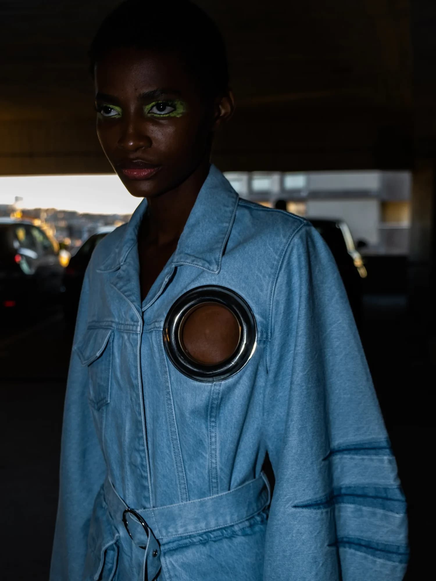 Model in denim jacket with cutout detail, backstage