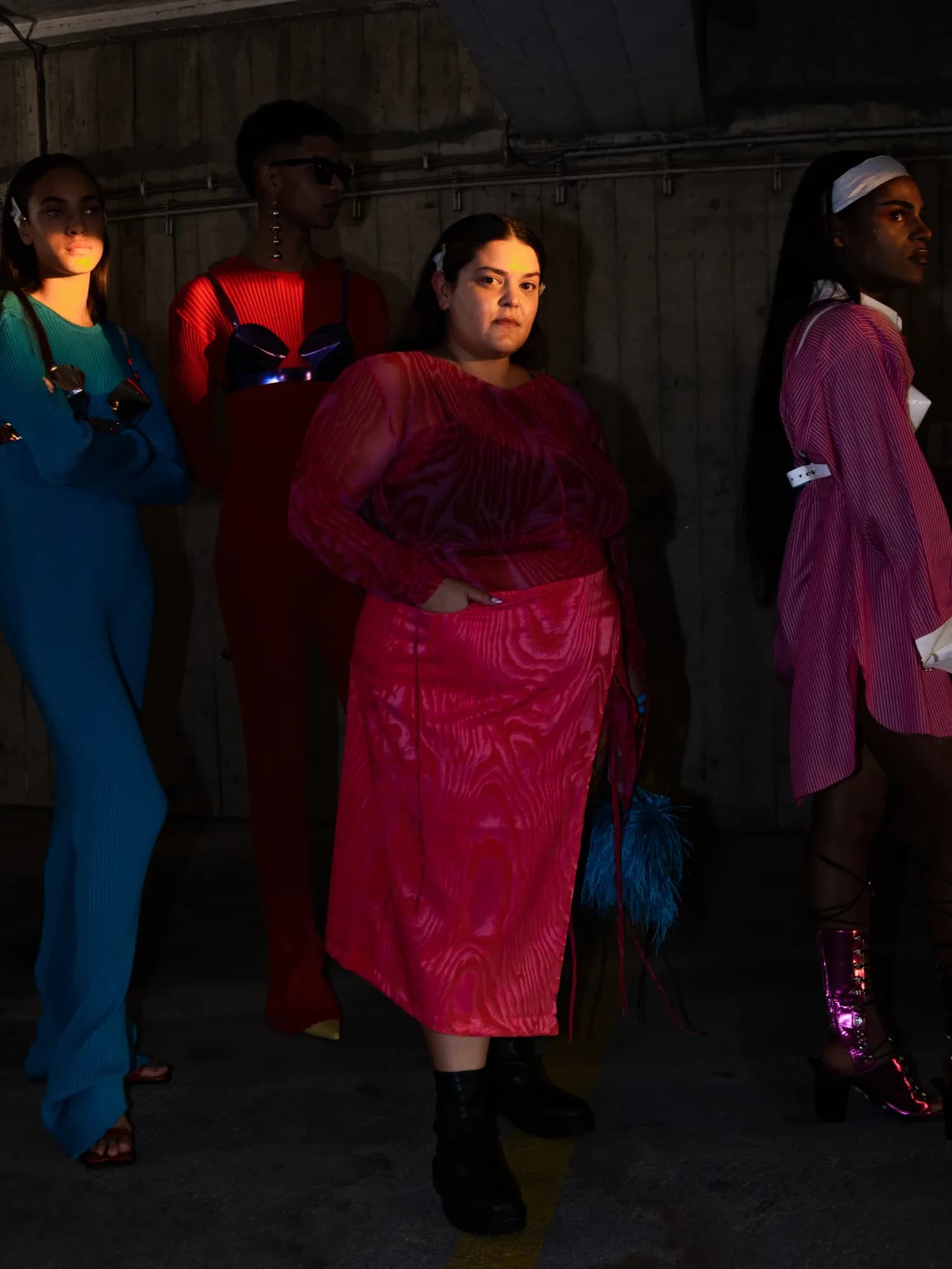 Group of models backstage under concrete lighting