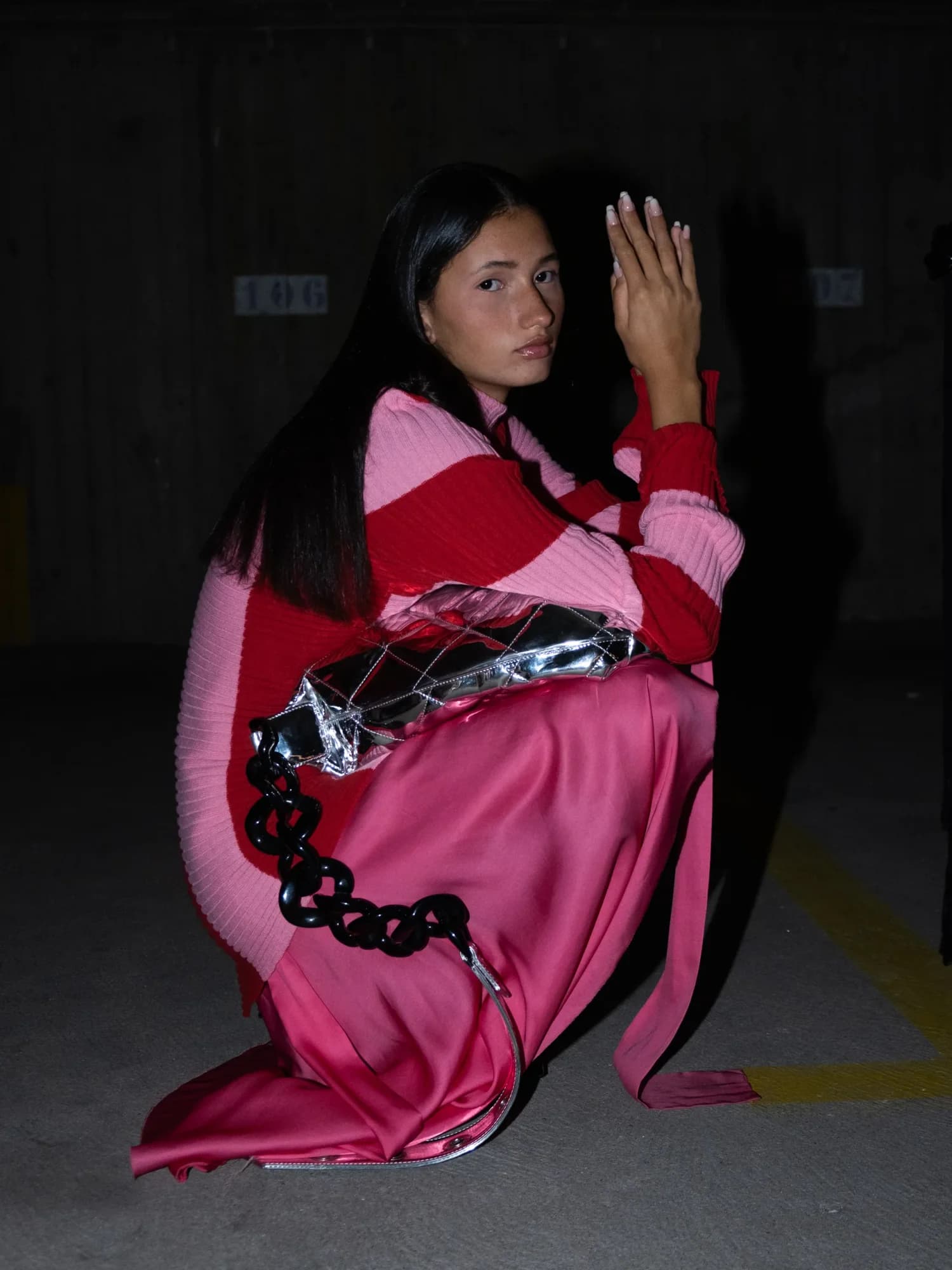 Kneeling model in pink and red knitwear