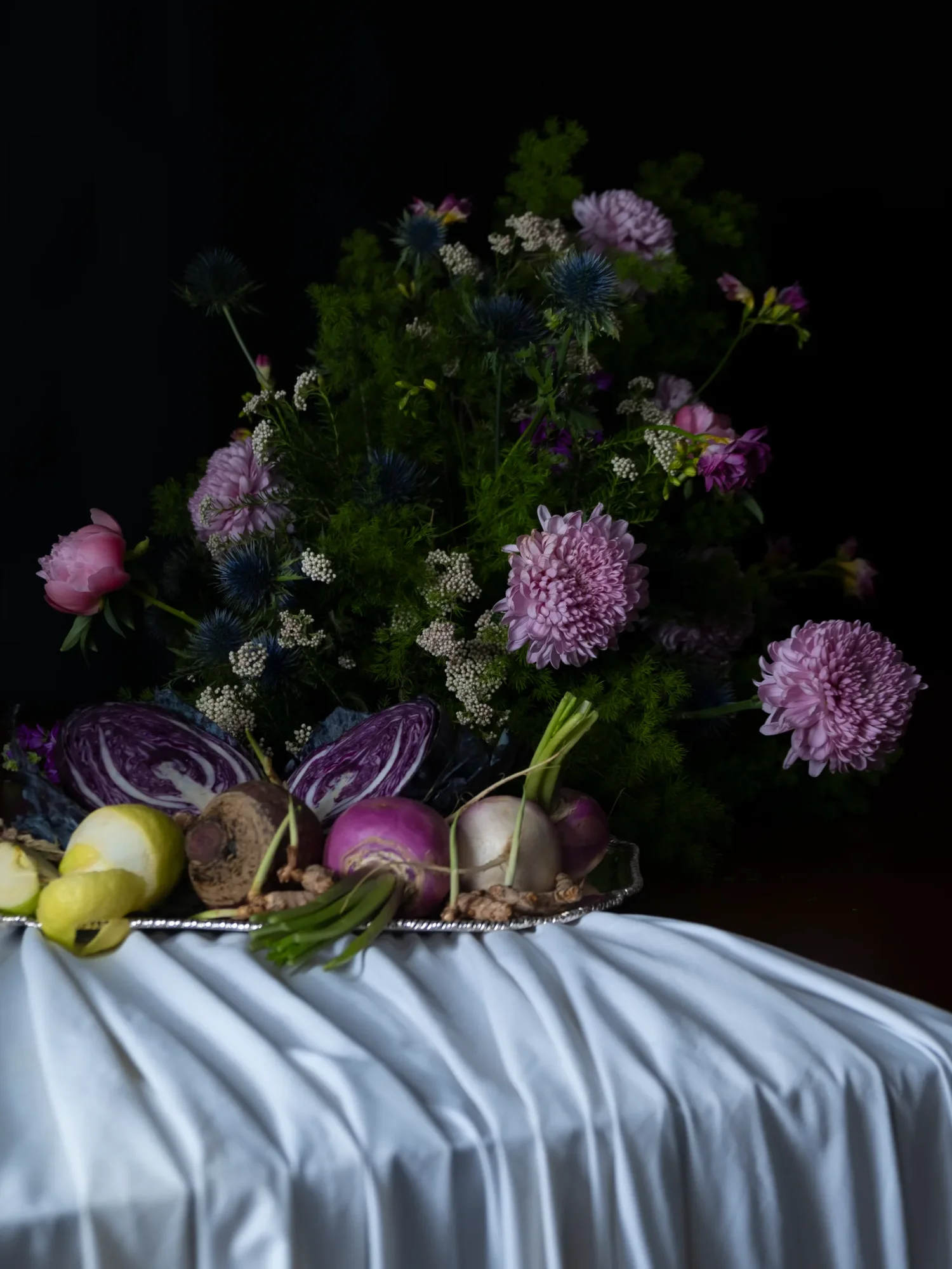 Lit taper candle atop a pearl-piped cone cake, dark background