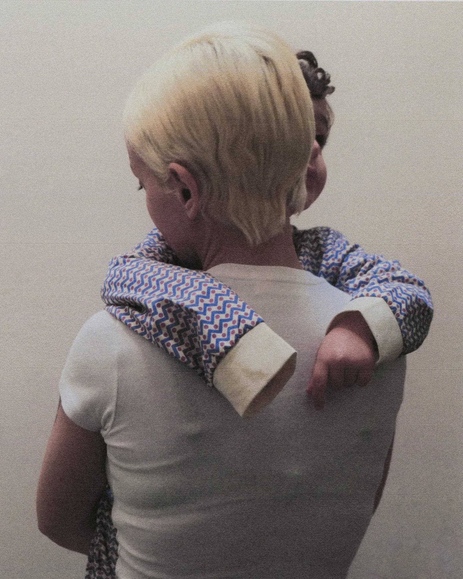 Back of a blonde head with patterned scarf detail