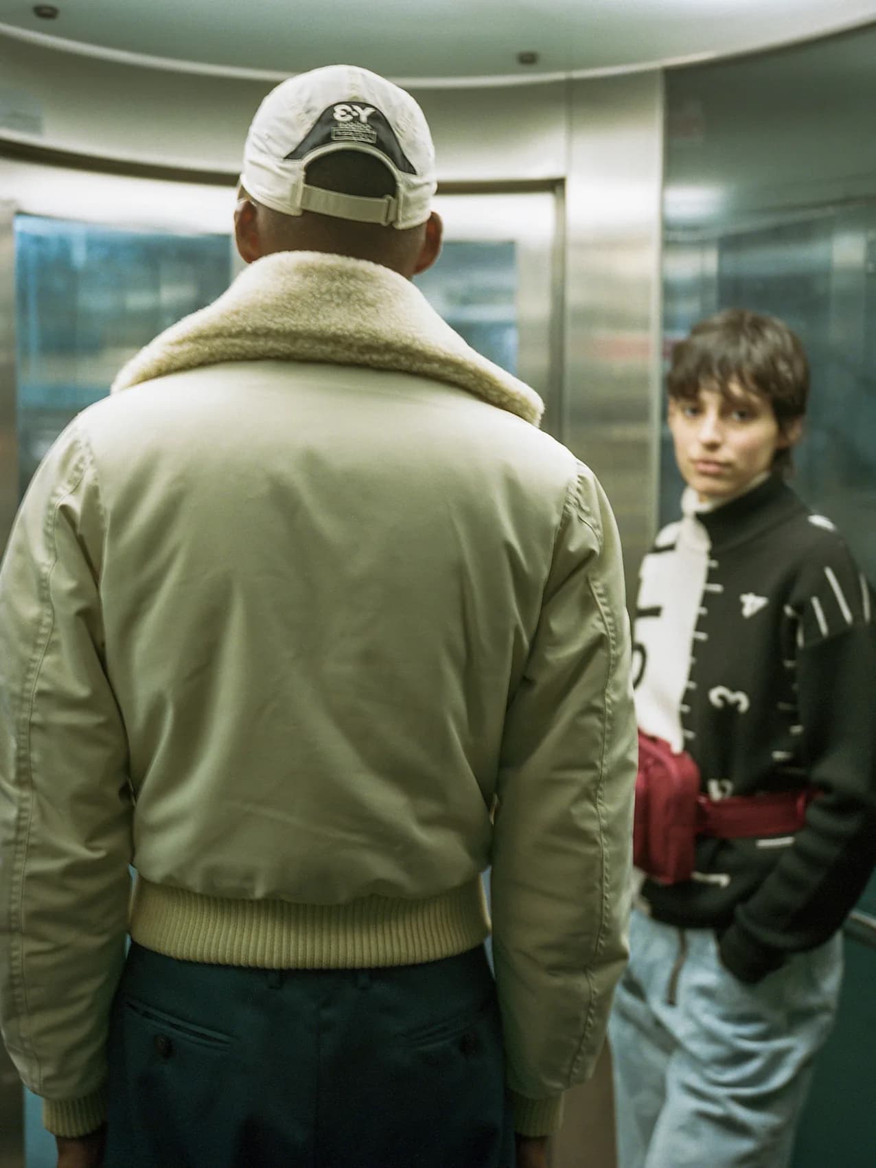Two figures in a dimly lit elevator